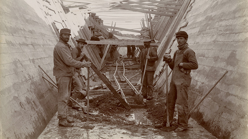 Workmen in lined tunnel with temporary rails, 1905. Photographer Walter J. Lubken. William E. Swift, Sr. Truckee Canal Construction Collection, NC1446.