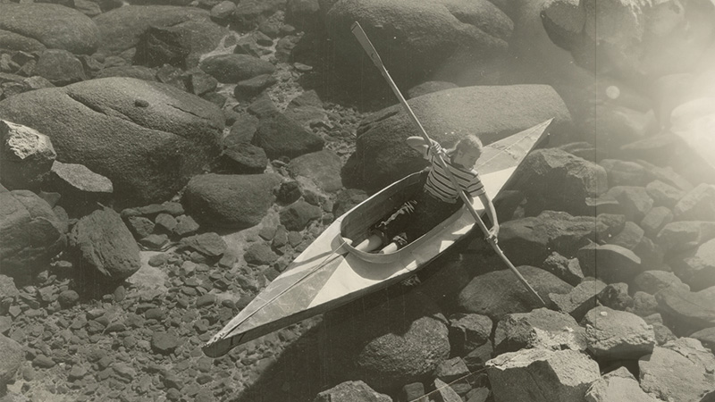 Photograph of a child in a kayak on Lake Tahoe. ID: UNRS-P1985-08-00626