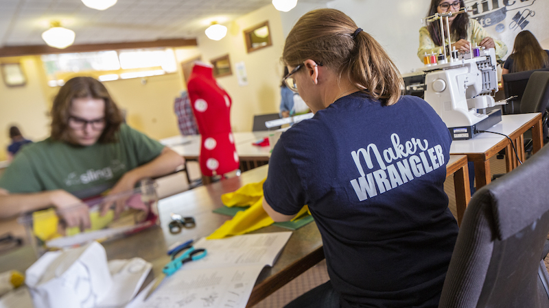 Maker wrangler working with students in the Sewing Suite