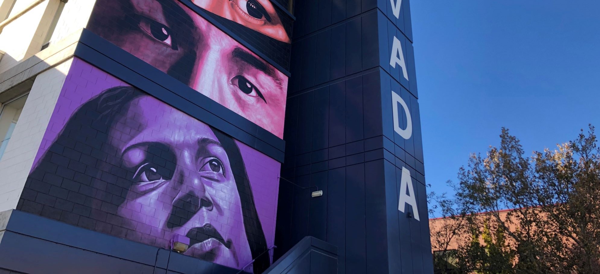 Photograph of the mural on the outside of Sierra tower showing diverse eyes with multicolored overlays
