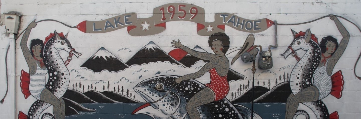 Street art showing a building with women in tattoos and swim suits riding seahorses and fish with a banner that says Lake Tahoe 1959 Queen of the Rodeo