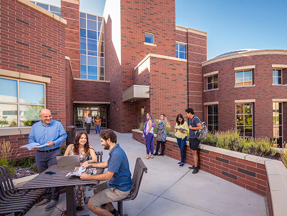 Exterior of the Basque Library. People mill about and chat at an outdoor table.