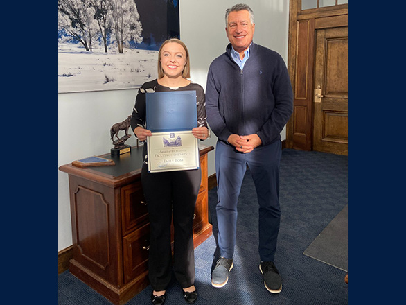 Emily Boss stands with University president Brian Sandoval.