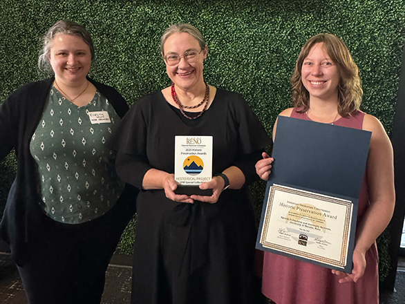 Three women pose for a picture holding the City of Reno award.