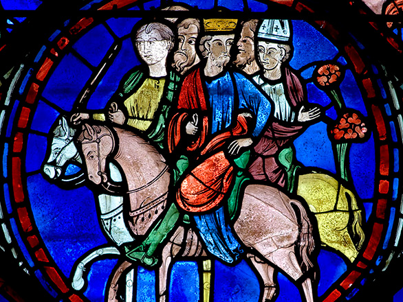 A vibrant stained glass window showing people on horses.