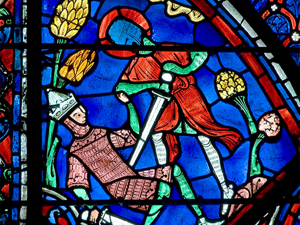 A vibrant stained glass window showing a man being stabbed by a sword by another man.