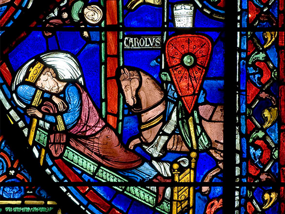 A vibrant stained glass window depicting a man sleeping and receiving word from God.