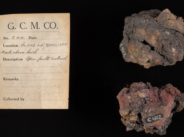“G.C.M. CO C412 Open Fault Material" printed on a card next to two rock samples on a black background