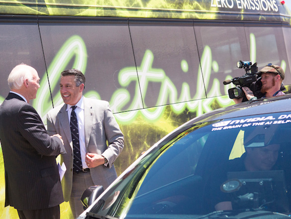 Governor Brian Sandoval shaking hands with a man, while another man films the interaction.