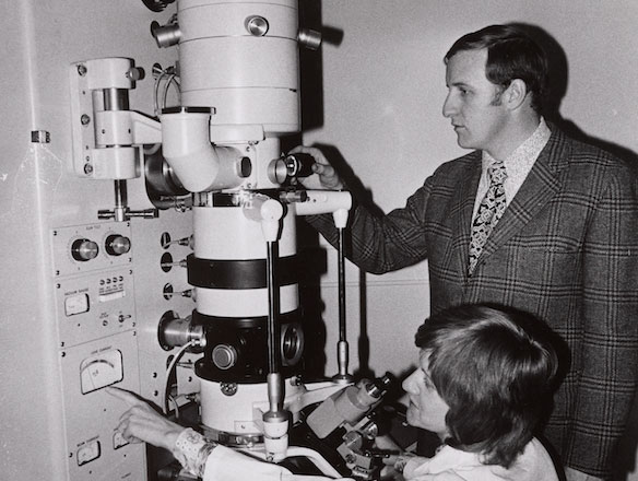 Medical Scientist Looking Through Microscope