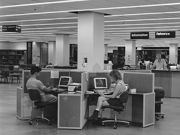 Students work at computer stations in nooks close to the reference desk in the Getchell Library. ID: