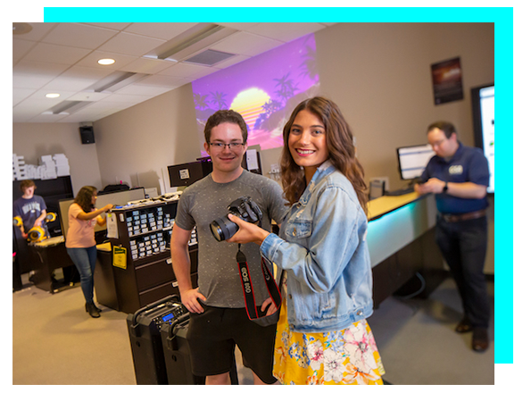 Students looking at a camera in front of the Lendable Technology desk in @One.