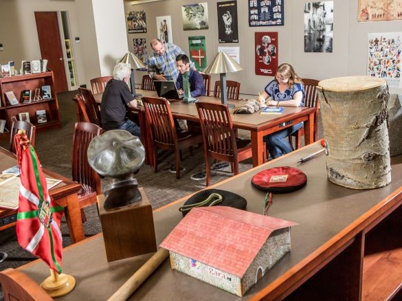 People studying in the Basque Library with a Basque flag in the foreground