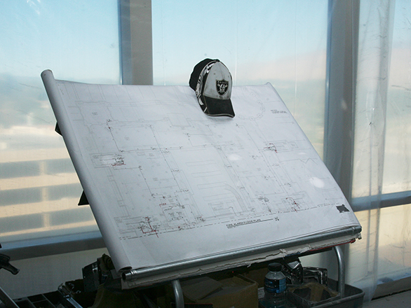 The library plans are propped up in display with a baseball cap placed on the edge of the plans. ID: UNRA-P3600-00245