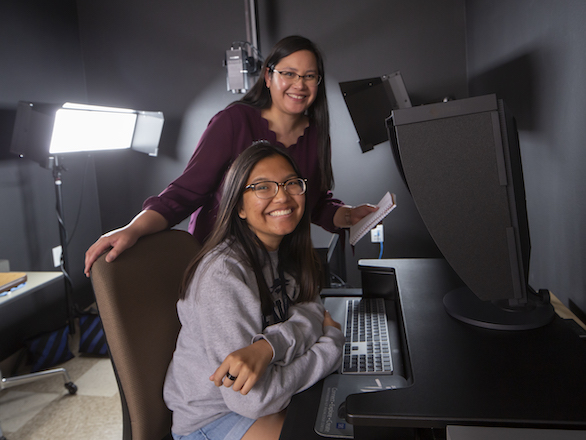 Digitization Lab Manager Katherine Dirk, standing, works with a student assistant in the Digitization Lab located in the Mathewson-IGT Knowledge Center.