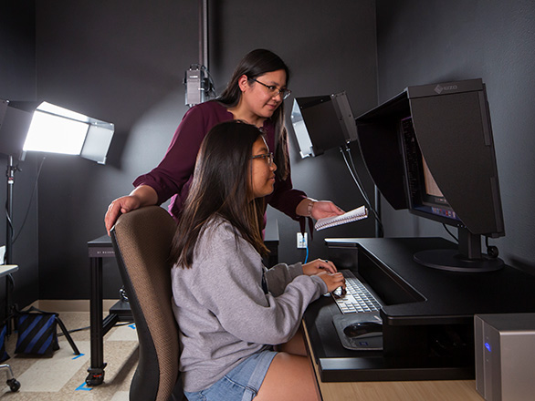 Katherine Dirk, Digitization Lab manager, works with a student assistant on a project.
