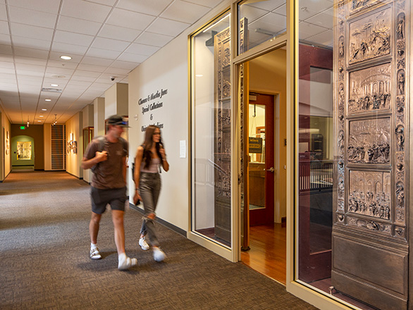 Two students walk by the entrance to Special Collections and University Archives.