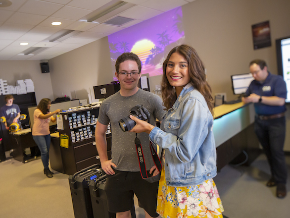 Students looking at a camera in front of the Lendable Technology desk in @One.