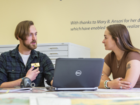 Team member helping a student in the Ansari Map Library.
