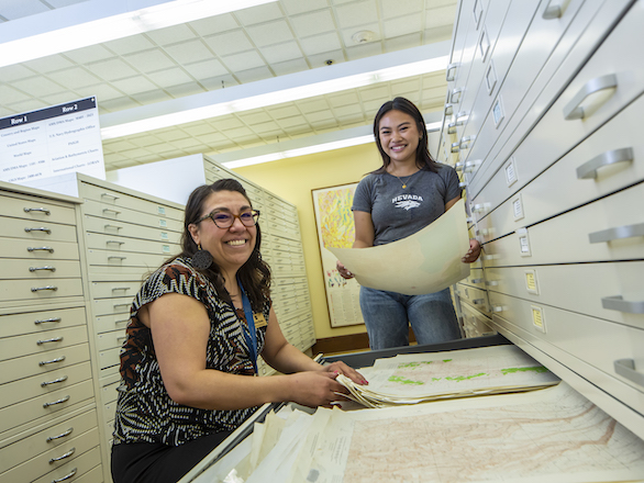 Librarian working with a student in the Ansari Map Library.