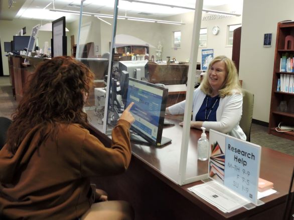 Student sitting in the KC getting instruction from a research librarian