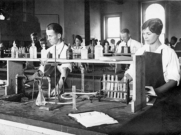 Chemistry students work amongst bottles and vials in the Chemistry Lab. ID: UNRA-P641-72.tif