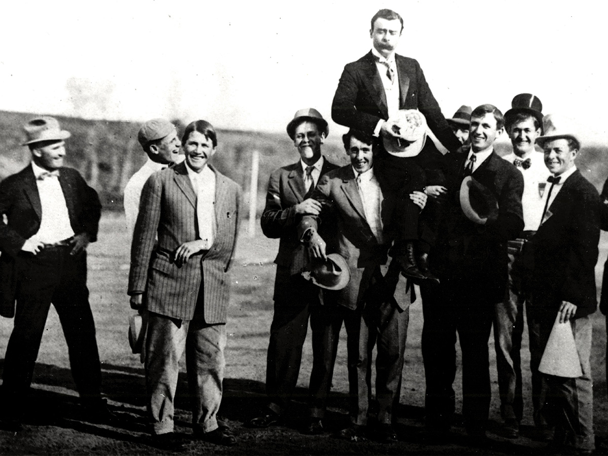 Clarence Mackay is held on the shoulders of a group of men during the Mackay Athletic Field dedication ceremony.