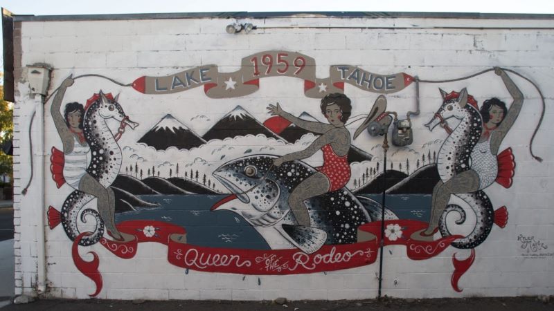 Street art with tattooed women in bathing suits riding seahorses and a fish with banners that say Lake Tahoe 1959 Queen of the Rodeo