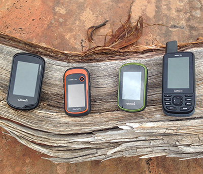 GPS devices sitting on a piece of wood.