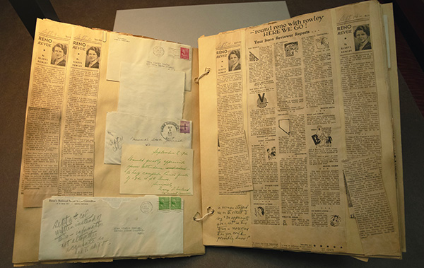 Scrapbook opened to show articles and letters.