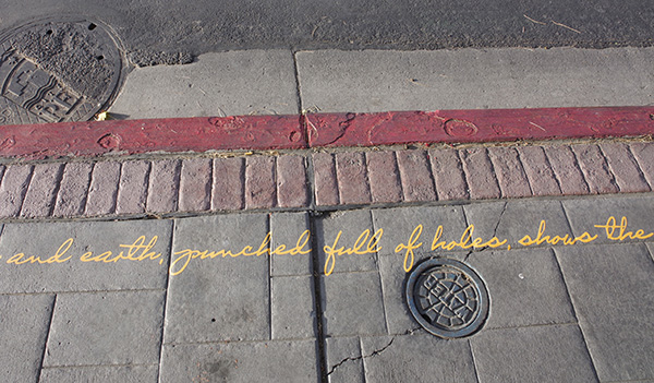 A handwritten message on an urban curb.