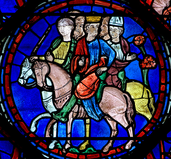 A vibrant stained glass window showing people on horses.