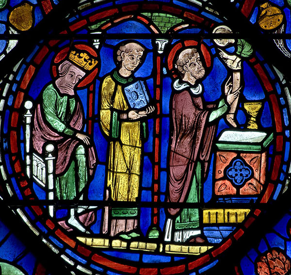 A vibrant stained glass window showing contemplative men.