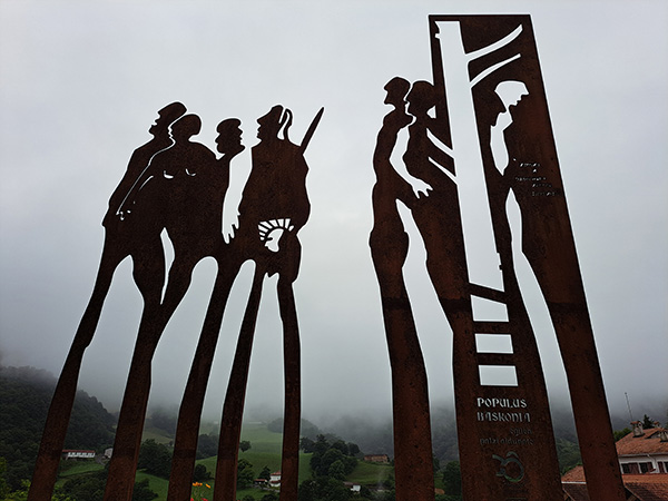 A metal sculpture depicting tall figures.