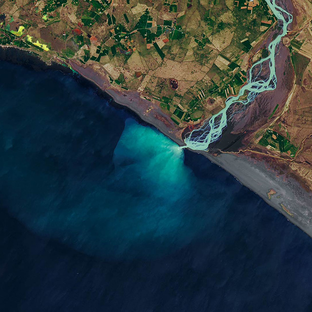 Overhead map view showing a river flowing into a larger body of water.