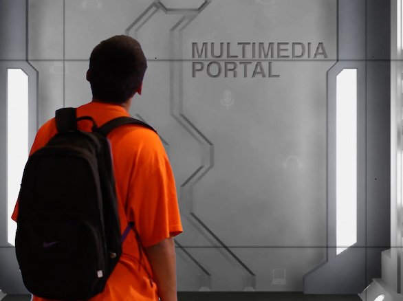 Cast member looking at a gate labeled "multimedia portal"